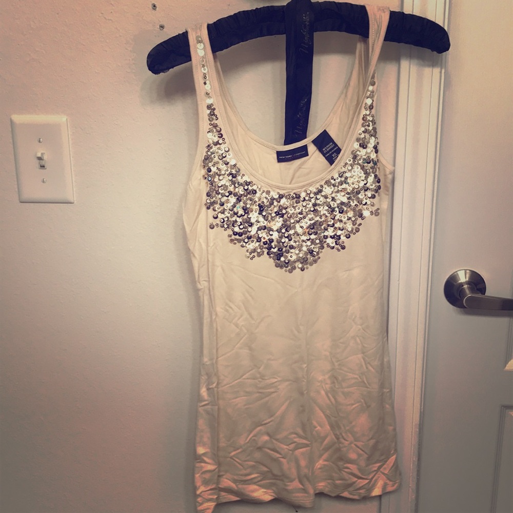 Beige fitted top with gold sequins.